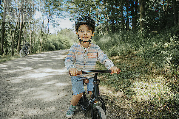 Smiling boy cycling on road