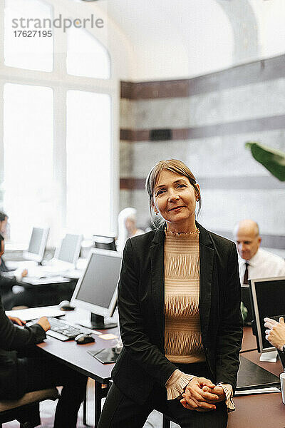 Porträt einer Geschäftsfrau  die in einer Anwaltskanzlei am Schreibtisch sitzt