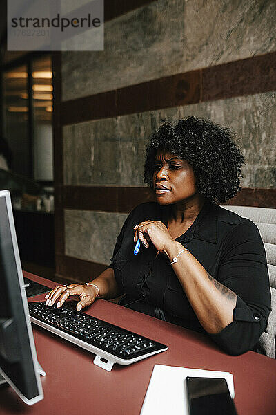 Geschäftsfrau mit Computer am Schreibtisch in einer Anwaltskanzlei