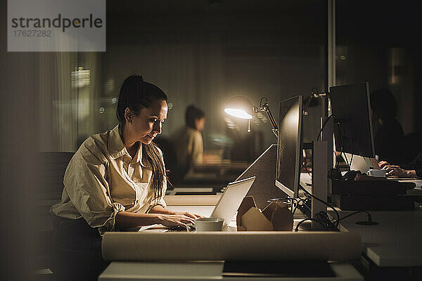Geschäftsfrau konzentriert sich bei der Arbeit an einem Laptop im Büro