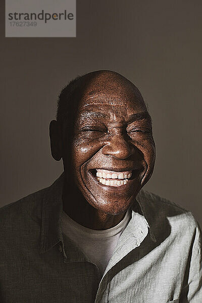 Älterer Mann lachend auf weißem Hintergrund