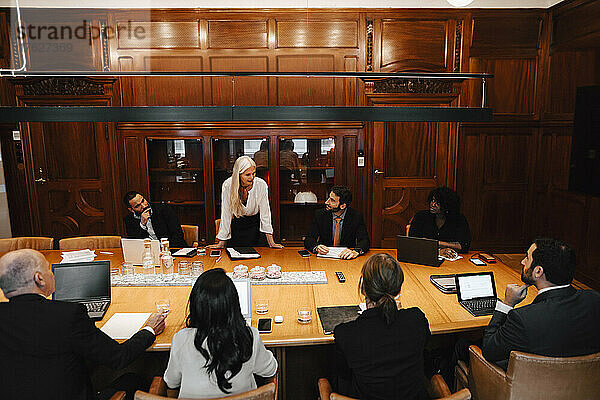 Reife Geschäftsfrau diskutiert mit Anwälten bei einem Treffen im Sitzungssaal