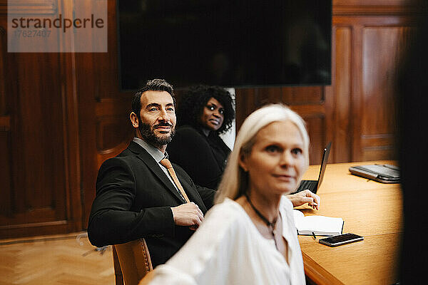 Gemischtrassige Kollegen sitzen während einer Sitzung am Konferenztisch im Sitzungssaal