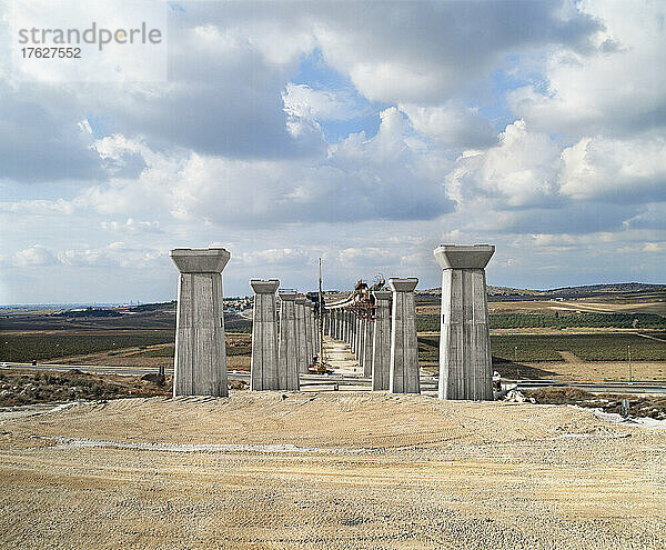 Im Bau befindliche Brücke  Pfeiler und Hochstraße durch eine trockene Landschaft.