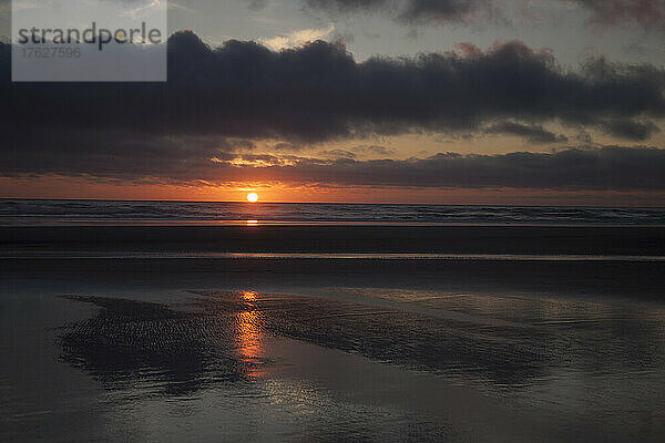 Cannon Beach mit dramatisch bewölktem Himmel bei Sonnenuntergang.