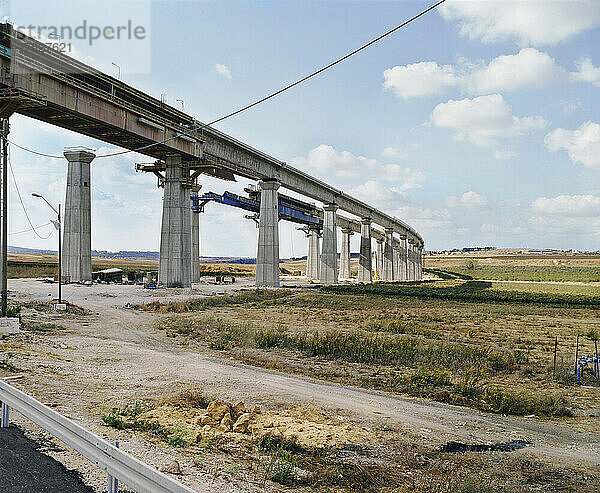 Im Bau befindliche Brücke  Pfeiler und Hochstraße durch eine trockene Landschaft.