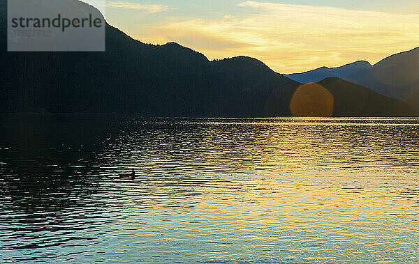 Eine Person beim Kajakfahren bei Sonnenuntergang im Howe Sound in der Nähe von Porteau Cove.