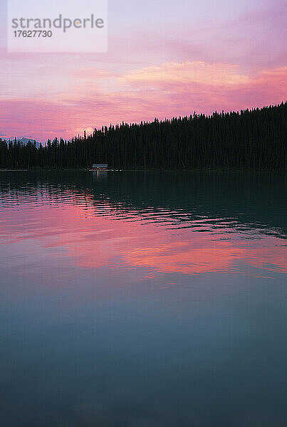 Lake Louise mit Reflexionen des rosa Himmels bei Sonnenuntergang.