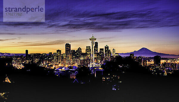 Mount Rainer hinter der modernen Skyline von Seattle in einer farbenfrohen Winterdämmerung.