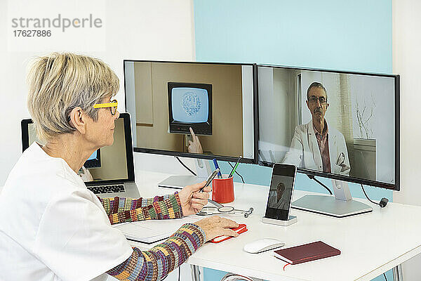 Telekonsultation zwischen zwei Ärzten mit einer Stammzelle auf einem der Bildschirme.