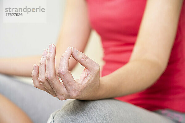 Nahaufnahme der Hände einer Frau während einer Meditationssitzung.
