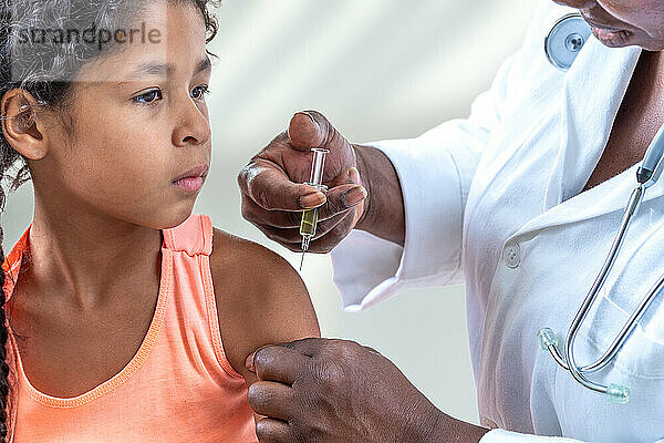 Kleines misstrauisches Mädchen bekommt eine Spritze  Impfung