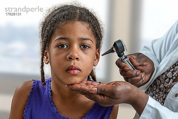 HNO-Arzt schaut mit einem Instrument in das Ohr des Patienten  Kind leidet unter Ohrenschmerzen