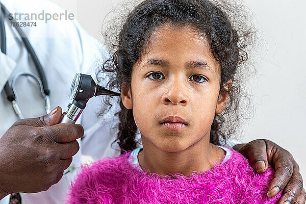 HNO-Arzt schaut mit einem Instrument in das Ohr des Patienten  Kind leidet unter Ohrenschmerzen