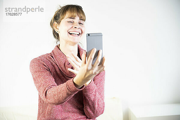 Äußerst freudige Frau beim Anblick ihres neuen Smartphones.