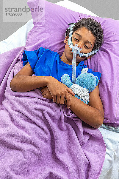 Kind leidet an Schlafapnoe und benutzt ein CPAP-Gerät