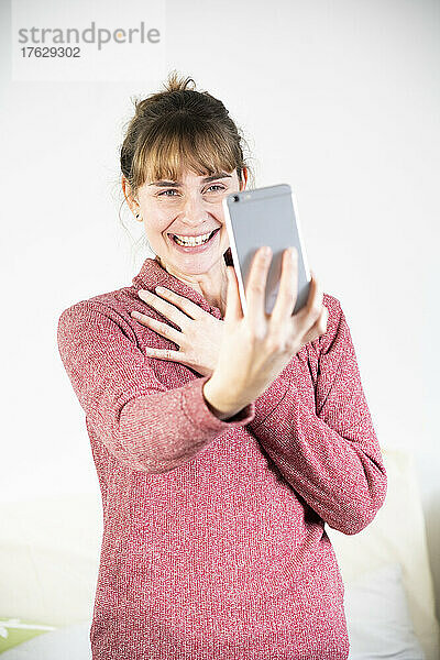 Äußerst freudige Frau beim Anblick ihres neuen Smartphones.