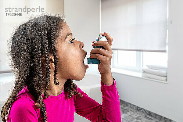 Nahaufnahme eines süßen 5-jährigen Mädchens  das seinen Asthmainhalator benutzt