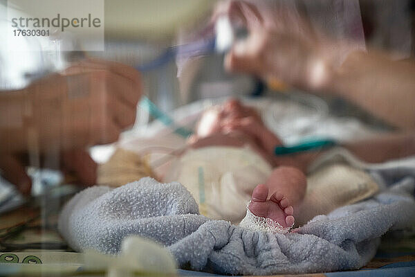Eine Mutter beteiligt sich an der Betreuung ihres Frühgeborenen.