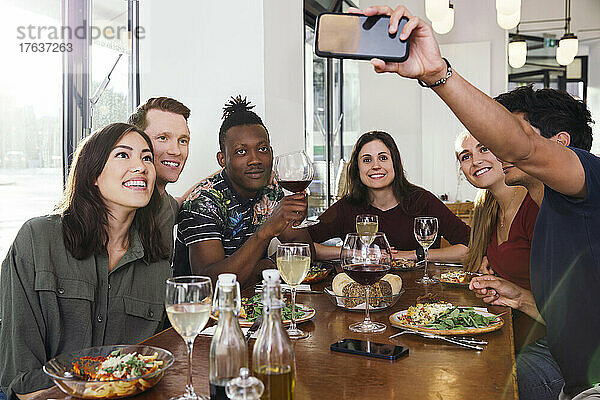 Lächelnde Freunde machen Selfie im Restaurant