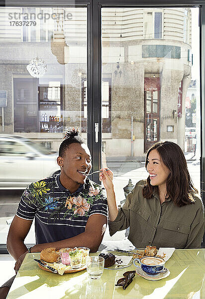 Lächelndes Paar teilt Essen im Restaurant
