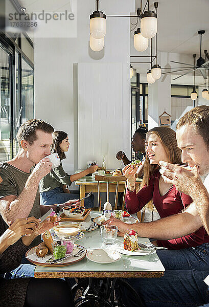 Eine Gruppe lächelnder Freunde genießt das Frühstück im Restaurant