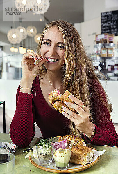Lächelnde Frau genießt Frühstück im Restaurant