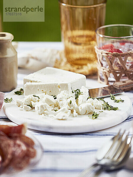 Feta-Käse mit Thymian auf Teller auf dem Tisch