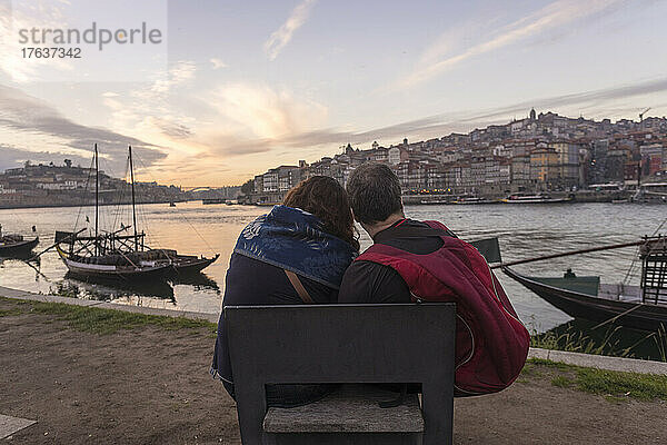 Portugal  Porto  Rückansicht eines Paares mit Blick auf den Fluss Douro bei Sonnenuntergang