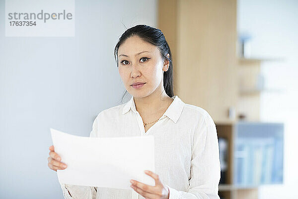 Porträt einer Geschäftsfrau mit Dokumenten im Büro