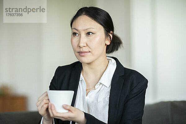 Geschäftsfrau mit Kaffeetasse im Büro