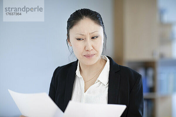 Geschäftsfrau schaut sich Dokumente im Büro an