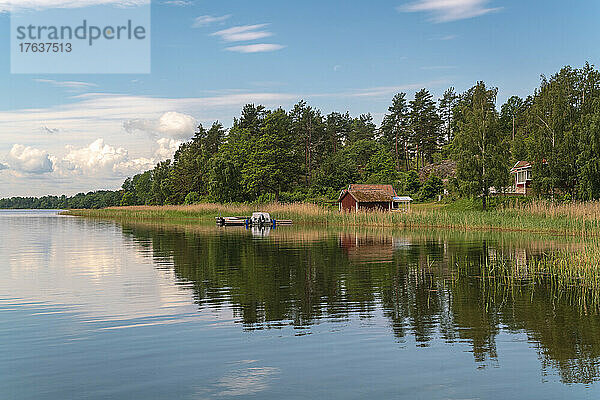 Schweden  Loftahammar  kleines Haus an der grasbewachsenen Küste