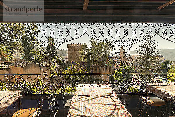 Marokko  Chefchaouen  Restauranttische mit Festung im Hintergrund