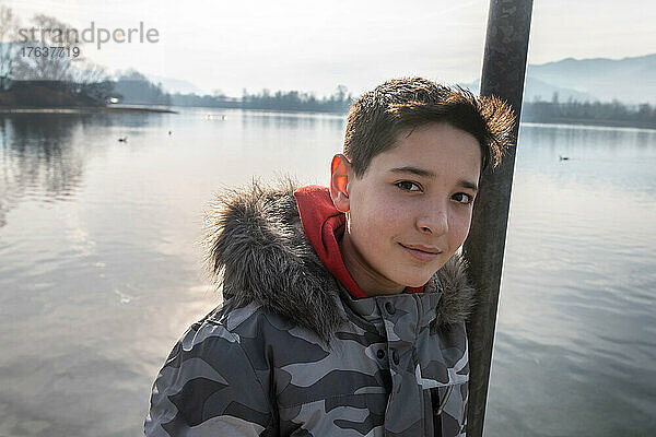 Italien  Porträt eines lächelnden Jungen  am ruhigen See