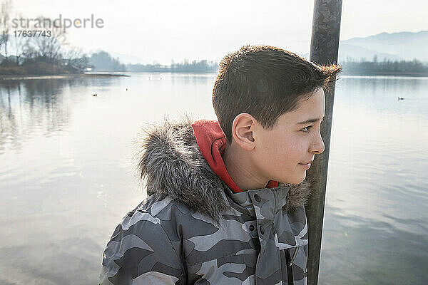 Italien  lächelnder Junge  am ruhigen See