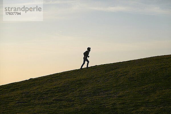 Reife Frau joggt den Hügel hinauf