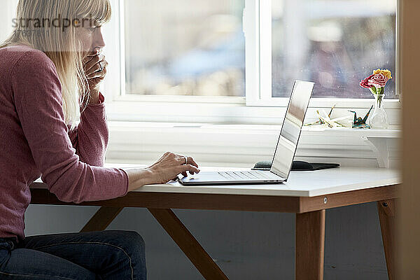 Frau benutzt Laptop zu Hause