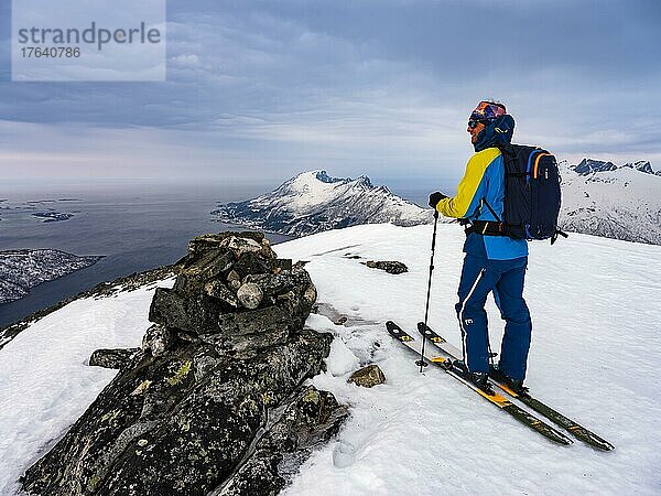 Skibergsteiger am Gipfel des Flobjörn mit Blick über den Bergsfjord  Insel Senja  Troms  Norwegen  Europa