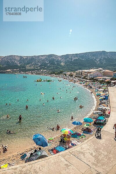 Blick auf einen vollen Strand in einer Bucht. Hauptsaison mit vielen Menschen die Baden und Sonnen  Baska  Insel Krk  Kroatien  Europa