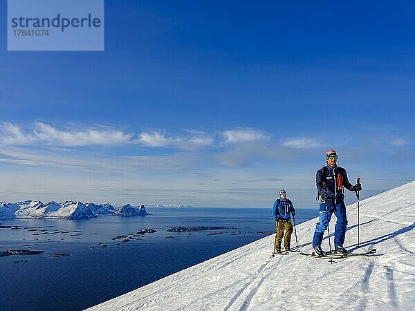 Zwei Skitourengeher im Aufstieg über dem Bergsfjord  Insel Senja  Troms  Norwegen  Europa