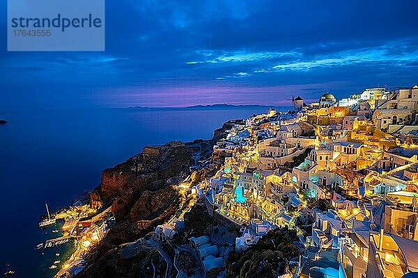 Berühmte griechische ikonischen Selfie Spot Touristenziel Oia Dorf mit traditionellen weißen Häusern und Windmühlen in Santorini Insel in den Abend blaue Stunde  Griechenland  Europa
