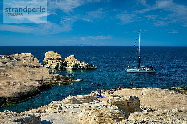 Yacht Boot am berühmten Sarakiniko Strand weißen Felsen touristische Attraktion mit Touristen am Strand in der Ägäis bei Sonnenuntergang  Milos Insel  Griechenland  Europa