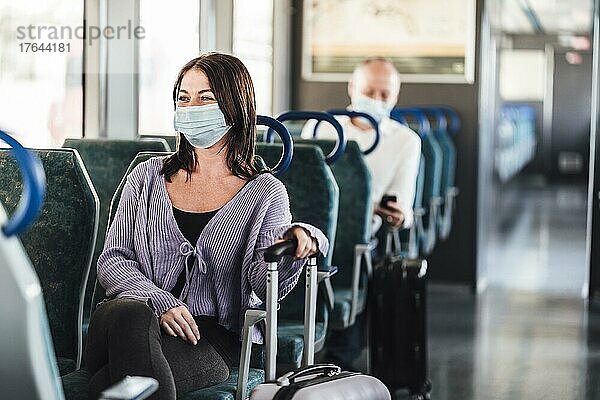 Positive commuters wearing mask enjoying their train trip