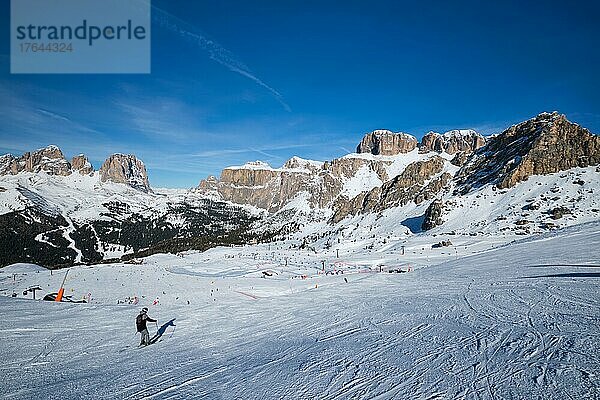 View of a ski resort piste with people skiing in Dolomites in Italy. Ski area Belvedere. Canazei  Italy