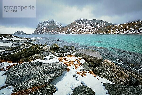 Rocky coast of fjord of Norwegian sea in winter with snow. Haukland beach  Lofoten islands  Norway