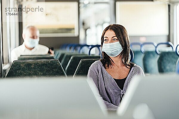 Positive commuters wearing mask enjoying their train trip