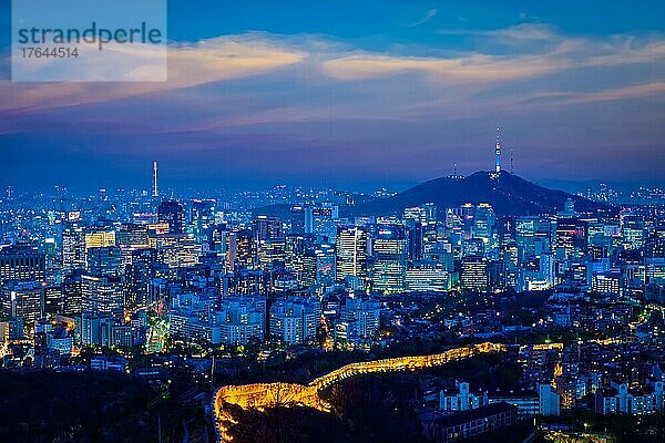 Seoul downtown cityscape illuminated with lights and Namsan Seoul Tower in the evening view from Inwang mountain. Seoul  South Korea