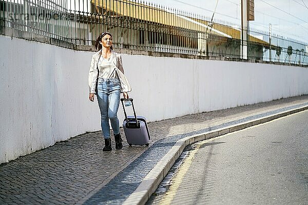 Portrait of traveling woman with luggage in urban settings
