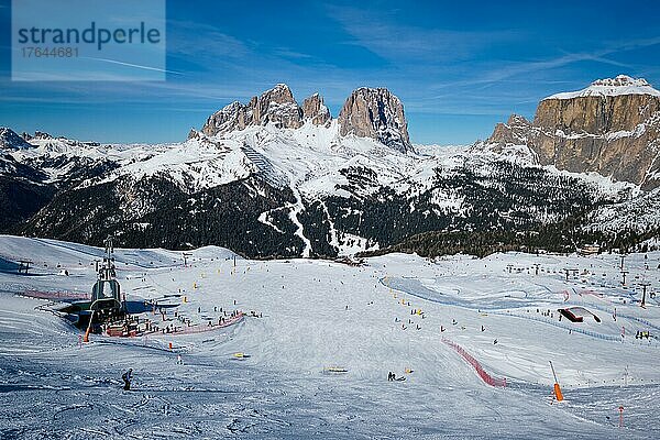 View of a ski resort piste with people skiing in Dolomites in Italy. Ski area Belvedere. Canazei  Italy